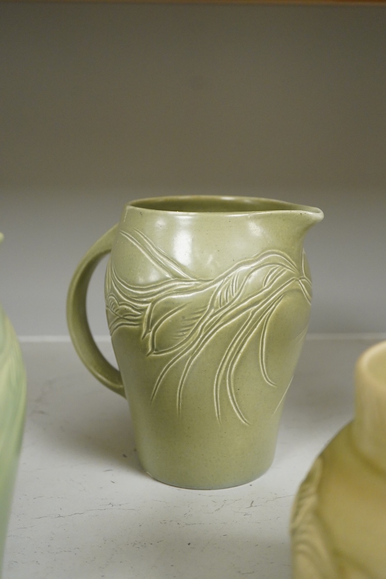 Three Susie Cooper green floral incised jugs, signed to the bases, tallest 16cm high
